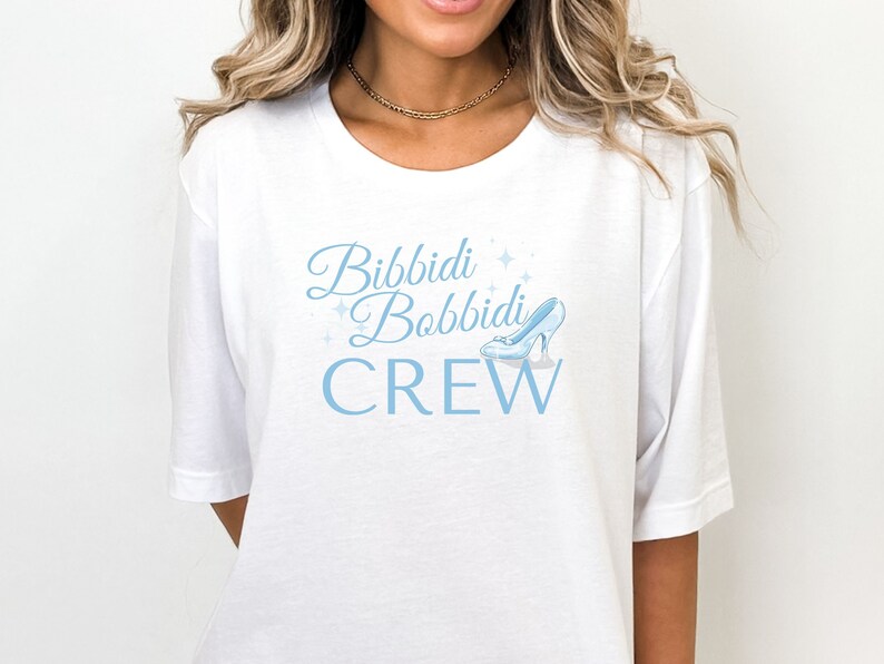 May include: White t-shirt with a blue graphic that says "Bibbidi Bobbidi Crew" with a glass slipper graphic.