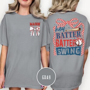 May include: Gray t-shirt with baseball-themed graphics. The front features a baseball bow with the name "MASON" and the number "31". The back displays the text "Hey Batter Batter Swing" with baseball and ribbon graphics.