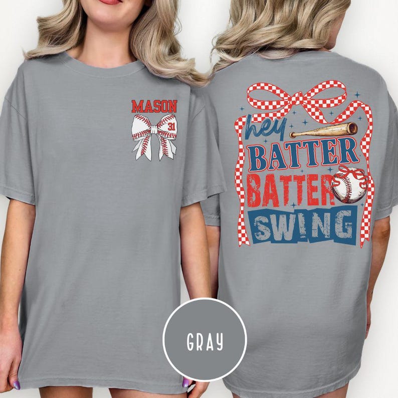 May include: Gray t-shirt with baseball-themed graphics. The front features a baseball bow with the name "MASON" and the number "31". The back displays the text "Hey Batter Batter Swing" with baseball and ribbon graphics.