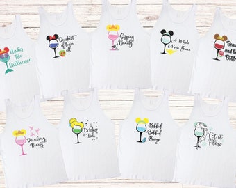 May include: Set of 8 white tank tops with different Disney princess-themed wine glass designs. Each tank top features a different princess with a wine glass and a funny saying. The sayings include "Under the Influence", "Druskest of them all", "Sipping Beauty", "A Whole New Buzz", "Drinking Beauty", "Drinker Bell", "Bobbidi Bobbidi Booze", and "Let it Flow".