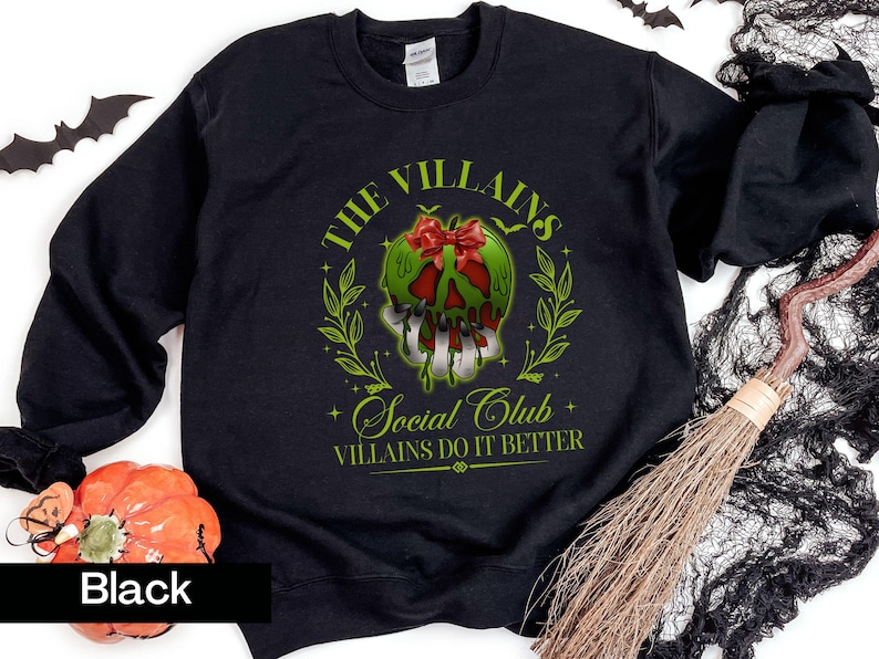 May include: Black sweatshirt with a green and red graphic of a skull with a bow, surrounded by leaves. Text reads "THE VILLAINS Social Club" and "VILLAINS DO IT BETTER". Halloween-themed apparel.