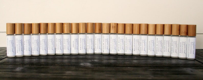 May include: A row of 30 small, clear glass bottles with bamboo caps. The bottles are labeled with the text "Groundwood" and "Naturally Scented".
