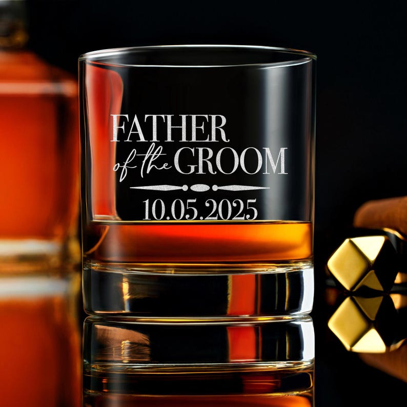 以下が含まれることがあります： 前面に「Father of the Groom」というテキストと「10.05.2025」という日付がエッチングされた透明なガラス製のロックグラスです。