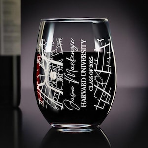 May include: A clear wine glass with an etched design of the Harvard University campus. The glass is filled with red wine and has the text "Jason Mackenzie, Harvard University, Class of 2025" etched on the side.