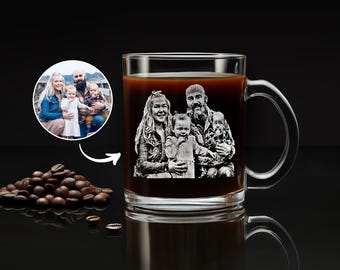 May include: A clear glass mug filled with dark coffee, featuring a white laser-etched engraving of a family portrait consisting of two adults and two children. A small circular inset shows the original color photograph used for the engraving.