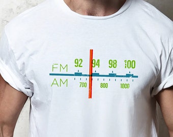 May include: White t-shirt with a vintage radio dial graphic. The dial shows FM frequencies from 92 to 100 and AM frequencies from 700 to 1000.