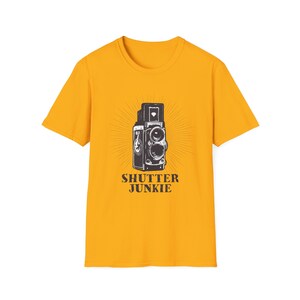 Dark yellow t-shirt featuring a retro camera design and "Shutter Junkie" text.