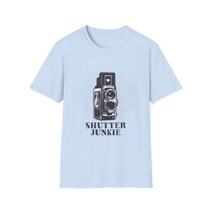 Red t-shirt featuring a vintage camera design and "Shutter Junkie" text.