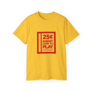 Unisex black gaming tee featuring classic arcade design with coin slot graphic and retro gaming text, ideal for arcade lovers.