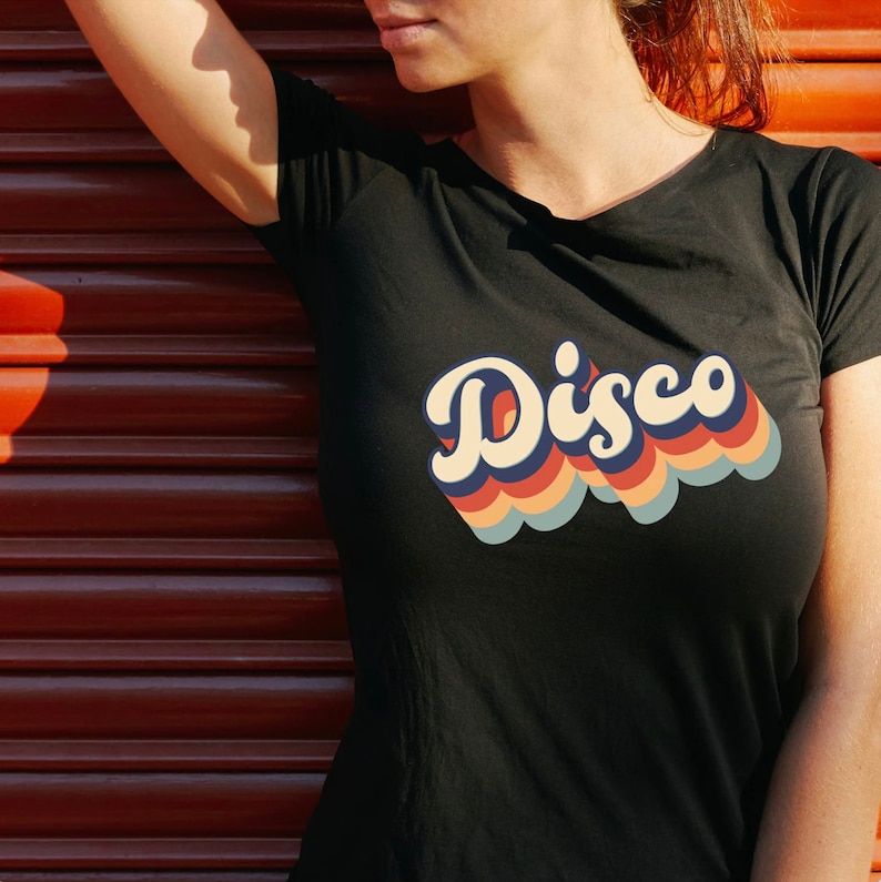 May include: A black t-shirt with a retro-style rainbow graphic that says "Disco" in a bold, colorful font.