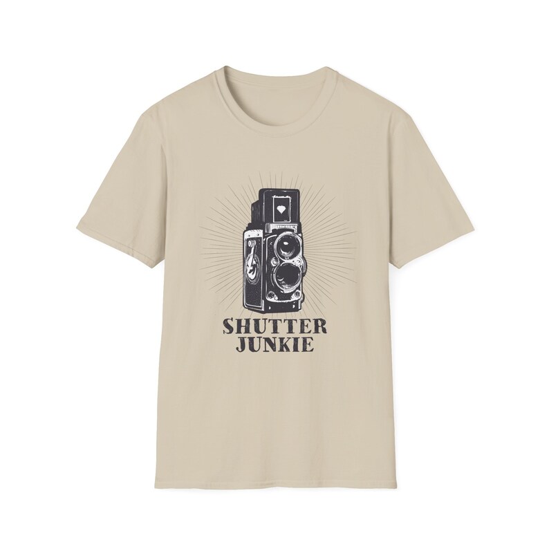 Beige t-shirt showcasing a vintage camera design and "Shutter Junkie" text.