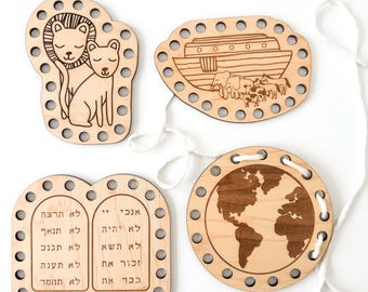 May include: Four wooden lacing cards with different themes: a lion and cub, Noah's ark, the Ten Commandments in Hebrew, and a world map. Each card has holes around the edge for lacing.