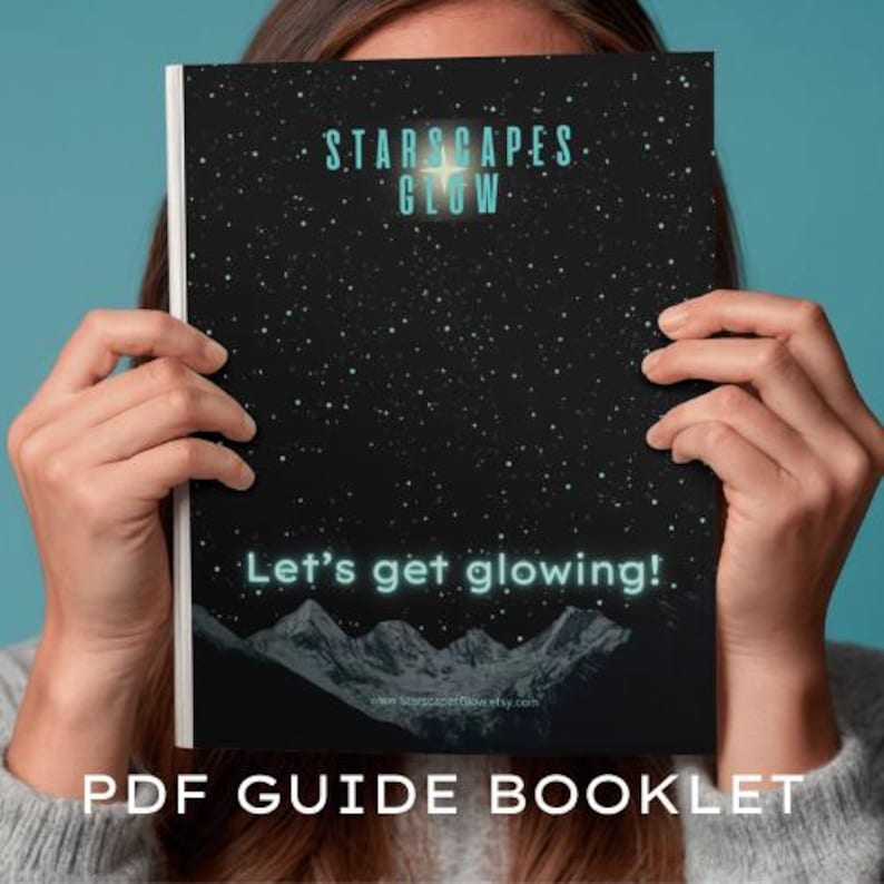 May include: A PDF guide booklet with a black cover featuring a starry night sky design. The text "STARSCAPES GLOW" and "Let's get glowing!" are in a glowing teal color. The bottom of the cover shows a mountain range.