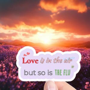 May include: A sticker with a pink cloud and the text "Love is in the air but so is the flu" with a small star and two red hearts.