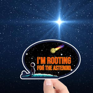 May include: A sticker with a cartoon figure standing on a green hill looking up at a comet with a rainbow tail. The text on the sticker reads "I'm rooting for the asteroid."