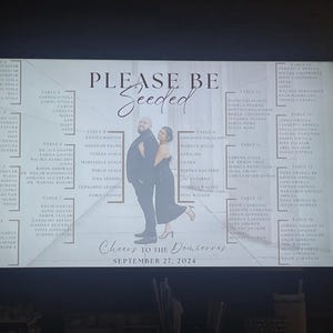 May include: A wedding seating chart with the words "Please Be Seeded" in elegant script. The chart includes a photo of a couple and the date "September 27, 2024". Names are listed under table numbers.