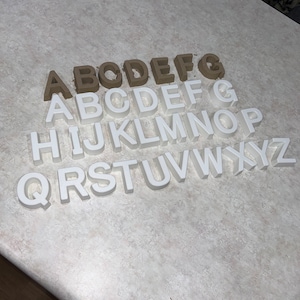 26 letras • Moldes de arena con el alfabeto • Refuerza el aprendizaje en casa o fuera de ella • Diseño ligero y agradable • Combínalos con arena cinética en cualquier lugar