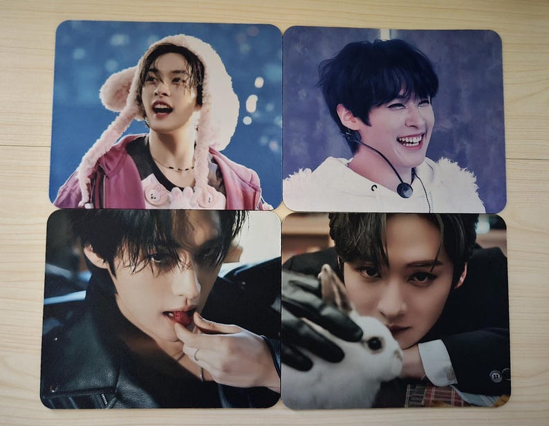 May include: Four square photo cards with images of young people. One card shows a person wearing a pink jacket and a furry hat. Another shows a person smiling. The third shows a person eating a strawberry. The last shows a person holding a white rabbit.