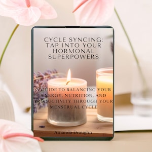 May include: A digital book cover with a white background and the title "CYCLE SYNCING: TAP INTO YOUR HORMONAL SUPERPOWERS" in black text. The subtitle is "A GUIDE TO BALANCING YOUR ENERGY, NUTRITION, AND PRODUCTIVITY THROUGH YOUR MENSTRUAL CYCLE". The author's name, "Amanda Draughn", is at the bottom of the cover.