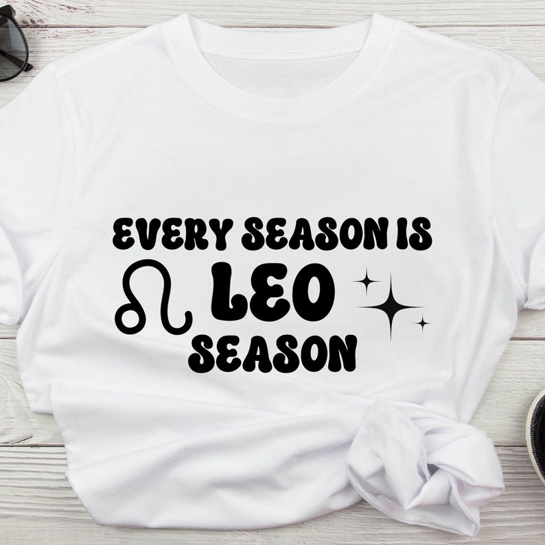 May include: White t-shirt with black text that reads "Every season is Leo season" with a Leo zodiac symbol and stars.