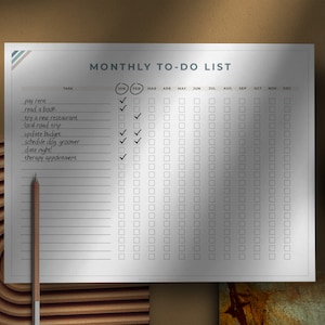 May include: A white monthly to-do list with a black and white striped header. The list includes tasks such as pay rent, read a book, try a new restaurant, local road trip, update budget, schedule dog groomer, date night, and therapy appointment. The list has checkboxes for each task for each month of the year.