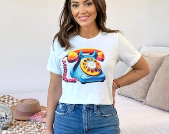 May include: White t-shirt with a colorful vintage rotary phone graphic.