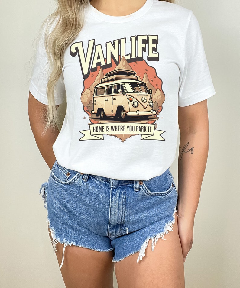 May include: White t-shirt with a graphic of a vintage camper van with the text "VANLIFE" and "HOME IS WHERE YOU PARK IT" printed on it.
