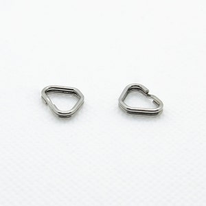 May include: Two silver-toned metal rings shaped like a triangle with rounded corners.