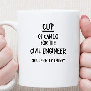 May include: White ceramic mug with the text "CUP OF CAN DO FOR THE CIVIL ENGINEER" in black. Below the text is "CIVIL ENGINEER ENERGY". The mug has a white handle.