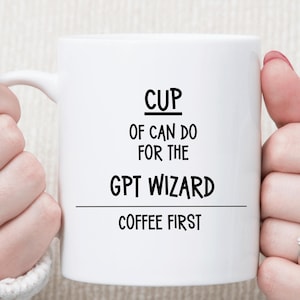 May include: White ceramic mug with the text "CUP OF CAN DO FOR THE GPT WIZARD COFFEE FIRST" in black. The mug has a handle and is held by a person.