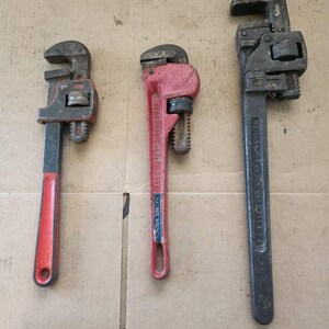 May include: Three pipe wrenches, one red, one black, and one silver, with different brand names and sizes.
