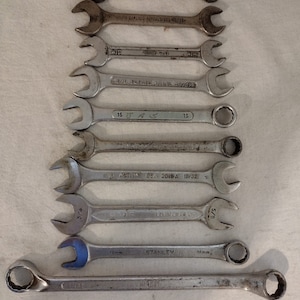May include: A set of ten wrenches in various sizes, including 3/4, 5/8, 15/32, 19/32, and 16mm. The wrenches are made of metal and have a silver finish. The wrenches are arranged in a vertical stack, with the largest wrench at the bottom and the smallest wrench at the top.