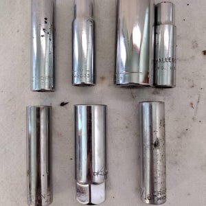 May include: A set of seven silver socket wrenches, some with markings like "CHALLENGED" and "CRAFT" on them.