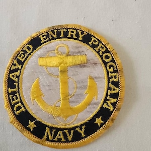 May include: A gold and black embroidered patch with the text "DELAYED ENTRY PROGRAM NAVY" and a gold anchor in the center.