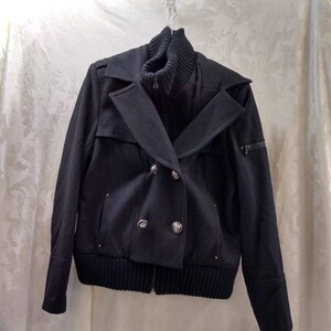 May include: A black double-breasted jacket with a zipper closure, a ribbed knit collar, and a ribbed knit waistband.