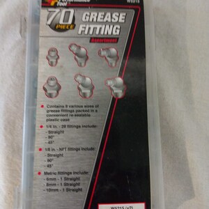 Op de afbeelding: Een 70-delige smeernippelset in een doorzichtige kunststof koffer. De koffer heeft een rood en zwart label met de tekst "Performance Tool 70 Piece Grease Fitting Assortment". Het label bevat ook het productnummer W5815 en W5215 (v2).