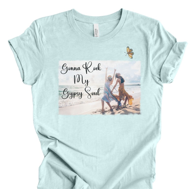 K&ouml;nnte beinhalten: Hellblaues T-Shirt mit einem Grafikdruck von zwei Frauen am Strand mit dem Text "Gonna Rock My Gypsy Soul".