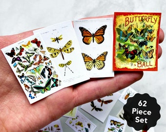 Può includere: Un set di 62 adesivi a forma di farfalla con farfalle colorate e dettagli intricati. Gli adesivi sono disposti su uno sfondo bianco con una mano che tiene gli adesivi. Il testo "The Butterfly Ball" è visibile su uno degli adesivi.