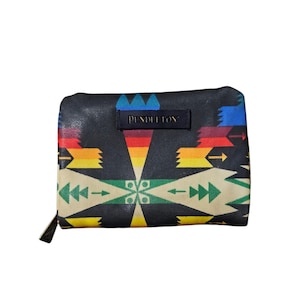 May include: A black wallet with a colourful geometric pattern and the brand name "PENDLETON" on a small black label. The wallet has a zip closure and a beige and black design.