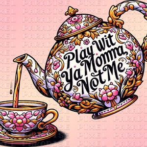 Puede incluir: Una tetera decorativa vierte té en una taza y un platillo. La tetera y la taza son blancas con diseños florales rosas y detalles dorados. El texto "Play Wit Ya Momma Not Me" está en la tetera.