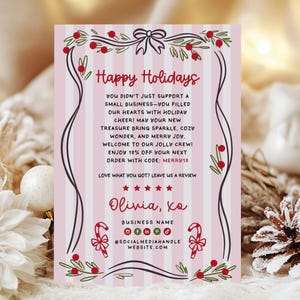 Puede incluir: Una tarjeta navideña festiva con un fondo a rayas rosas y blancas. La tarjeta presenta el texto "Happy Holidays" en escritura roja, junto con un mensaje, un código de descuento e información de redes sociales. Los adornos incluyen lazos, bastones de caramelo y bayas.