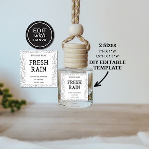 Puede incluir: Plantilla editable de bricolaje para ambientadores de coche. La plantilla presenta una etiqueta blanca con texto negro que dice "Fresh Rain" y un diseño de hojas. La etiqueta está unida a una botella de vidrio transparente con una tapa de madera y un colgador de cuerda marrón. La plantilla está disponible en dos tamaños: 2,5 cm por 2,5 cm y 3,8 cm por 3,8 cm.