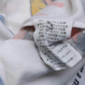 May include: White cotton fabric with a blue and white striped pattern. The fabric has a tag with Japanese text that includes instructions for washing and caring for the fabric.