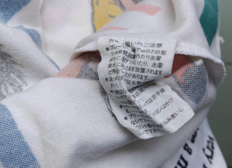 May include: White cotton fabric with a blue and white striped pattern. The fabric has a tag with Japanese text that includes instructions for washing and caring for the fabric.
