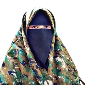Puede incluir: Una persona que lleva un niqab negro con un pañuelo con estampado de camuflaje. El pañuelo presenta una mezcla de tonos verdes, marrones y azules. El fondo es blanco liso.