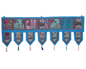 May include: A blue and multi-colored fabric valance with embroidered floral designs and tassels. The valance is made of patchwork fabric and has a scalloped edge.