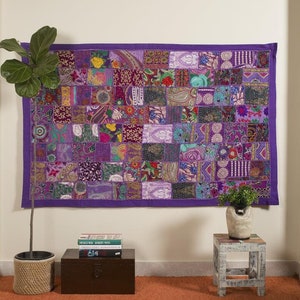 May include: A purple patchwork wall tapestry with a variety of colorful patterns and textures. The tapestry is made of fabric scraps sewn together in a random pattern. It is a great way to add a touch of color and personality to any room.
