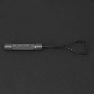 May include: A grey metal tool with a handle and a wire loop at the end. The loop is shaped like a triangle with a small opening at the top.
