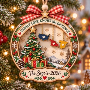 May include: A round wooden Christmas ornament featuring a red and white gingham bow, a green Christmas tree with gifts, and three hanging map cutouts of the USA, Georgia, and Spain. The text reads FAMILY LOVE KNOWS NO DISTANCE and The Sego's-2026.