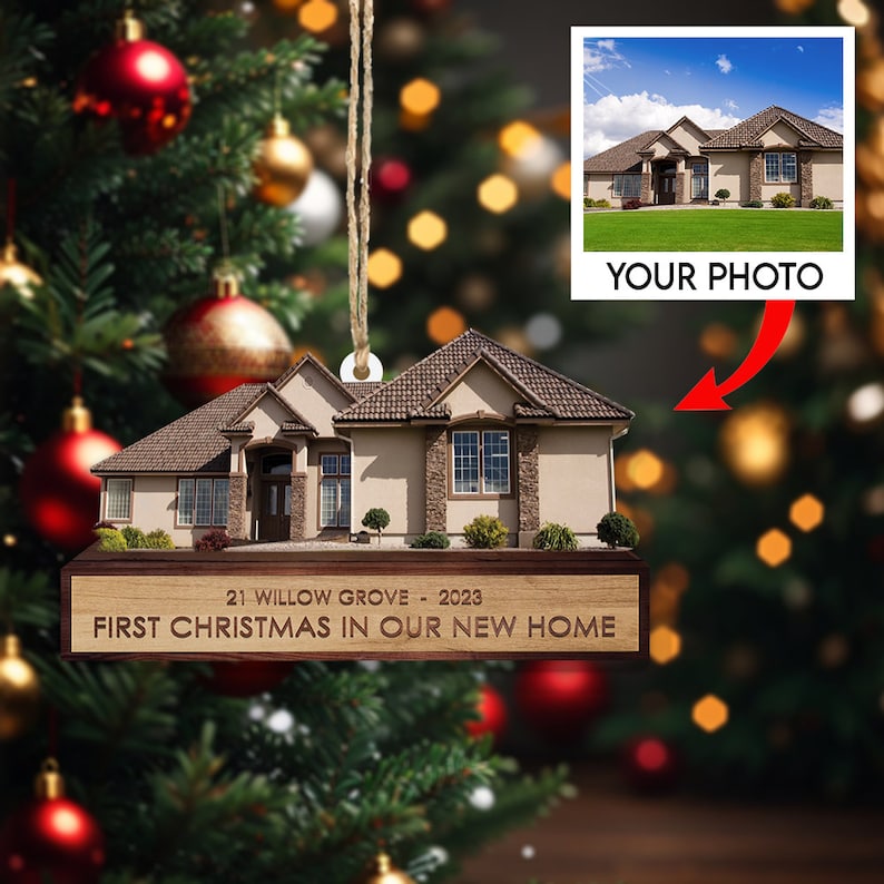 May include: A wooden Christmas ornament shaped like a house with a brown roof and tan siding. The ornament has a personalized inscription that reads "21 Willow Grove - 2023 First Christmas in Our New Home". A photo of a house can be uploaded to the ornament.